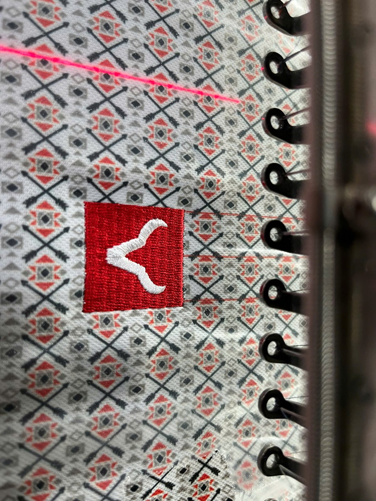 Close-up of all-over print sublimation fabric with embroidery logo at Onospod factory